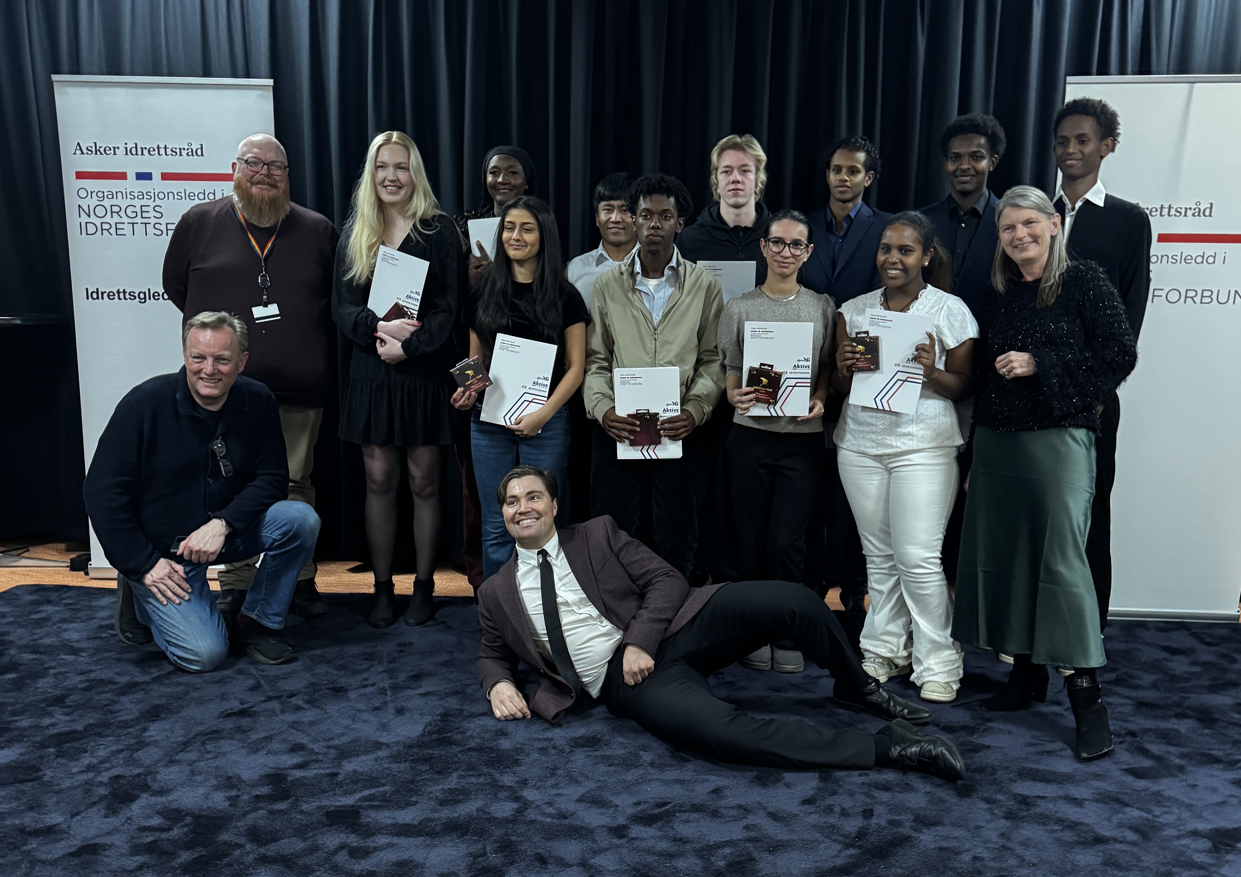 Fra venstre: Gorm Haugen (Styreleder Asker Idrettsråd), Christer Best Gulbrandsen, Victoria Valderhaug, Julliet Uwituje, Hema Lendi, Nemat Hassini, Salmaan Faysal, Magnus Hauge, Miriam Guzman-Henriksen, Anas Jama, Saron Negasi, Jonis Ateie, Adan Addib, Lene Conradi. Liggende foran: Falk Eidsvold Tøien